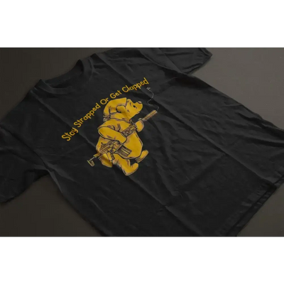 Black unisex t-shirt with Winnie the Pooh graphic and 'Stay Strapped or Get Clapped' slogan for edgy style.